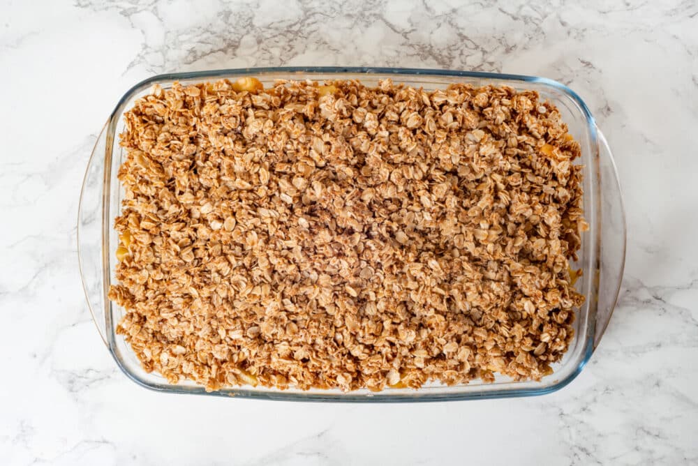 Crisp topping added to a glass pan, ready to bake.