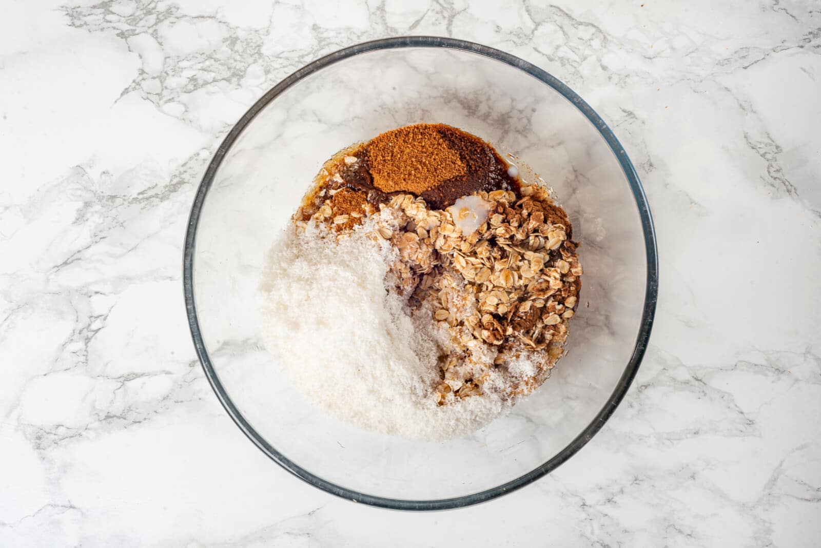 Apple crisp topping ingredients mixing in a glass bowl.