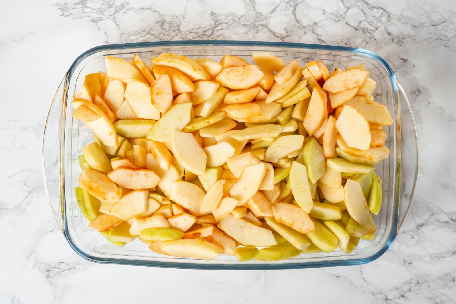 Apples, cut and sliced in a glass pan.