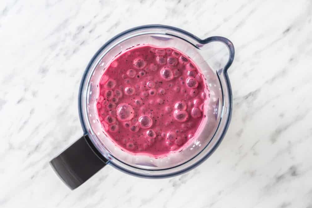 blended coconut blueberry and banana smoothie in a blender.