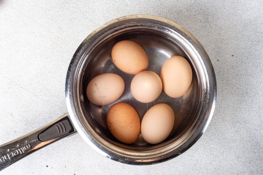 Boiled eggs in a silver pot.