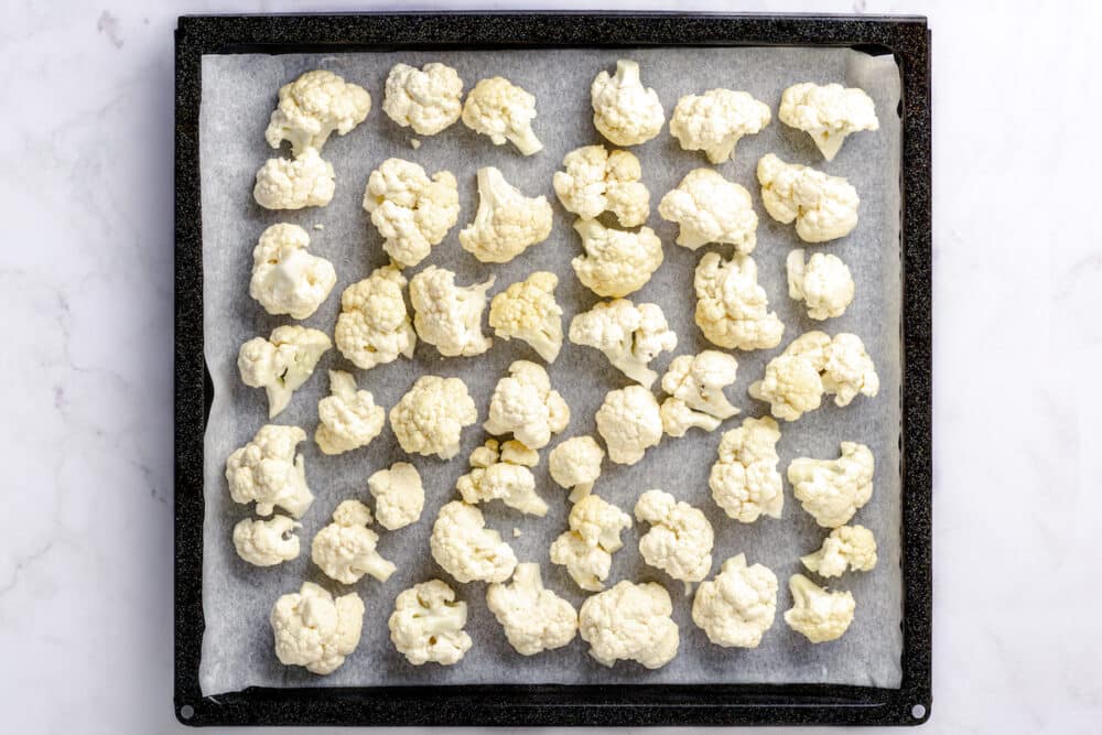 fresh cauliflower florets on a baking sheet.