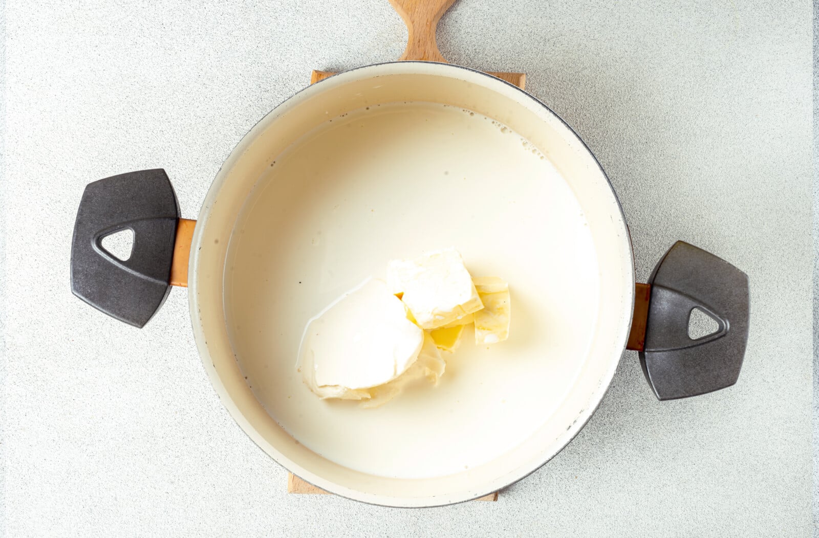 Butter melting in a pot with heavy cream.