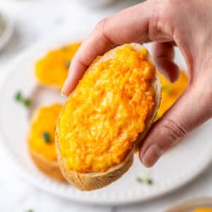 holding up a carrot melt crostini appetizer.