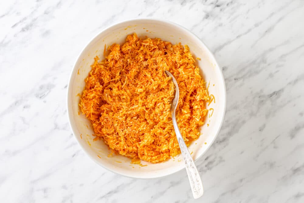 carrot melt mix in a white bowl with a spoon.