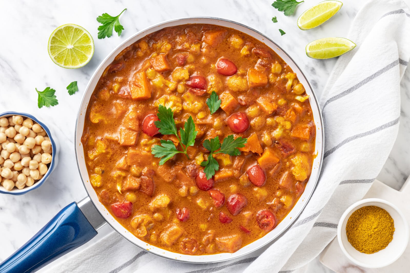 curry garnished with parsley with limes on the side.