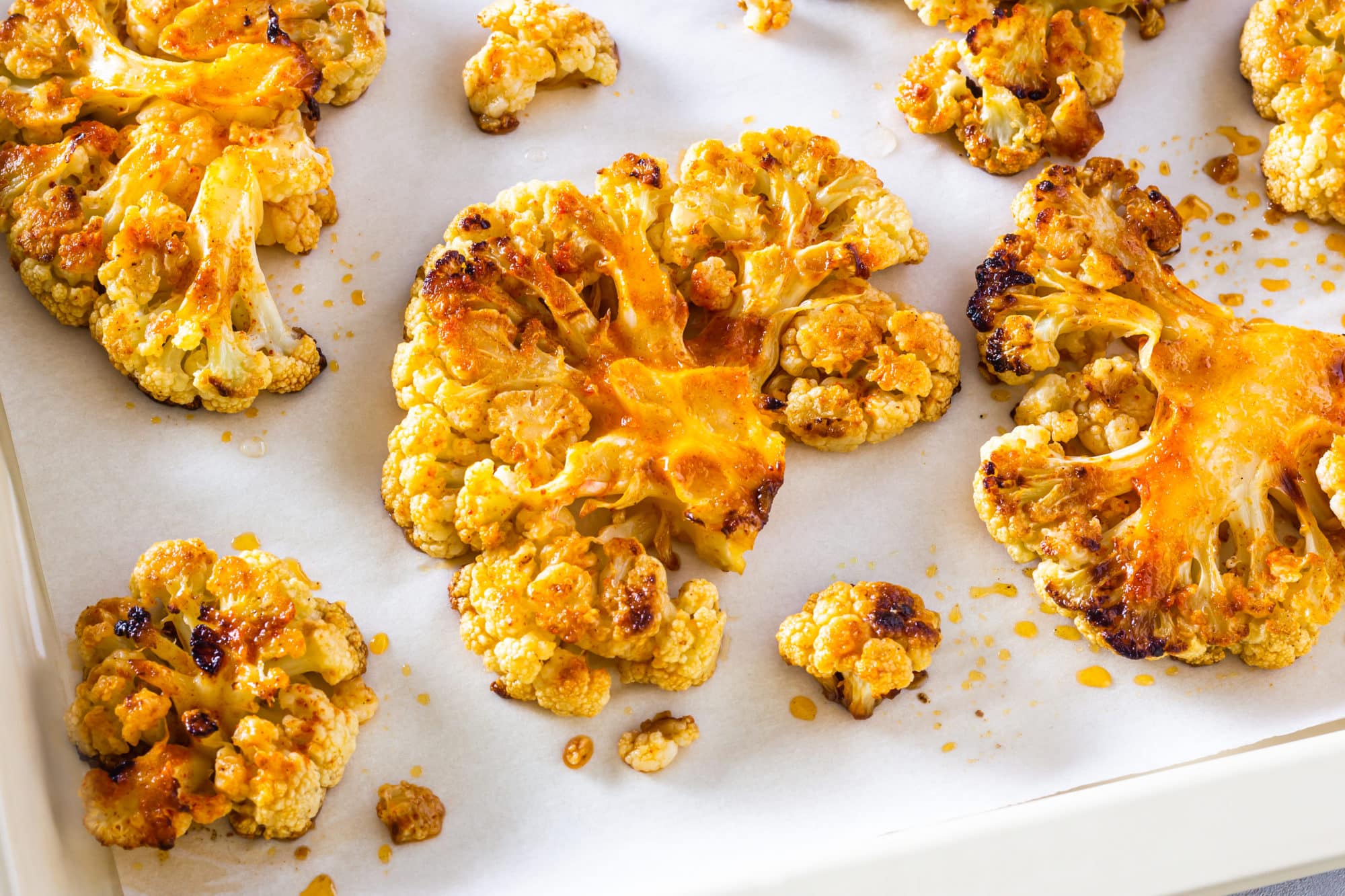 a baking tray with parchment paper and roasted cauliflower steak.