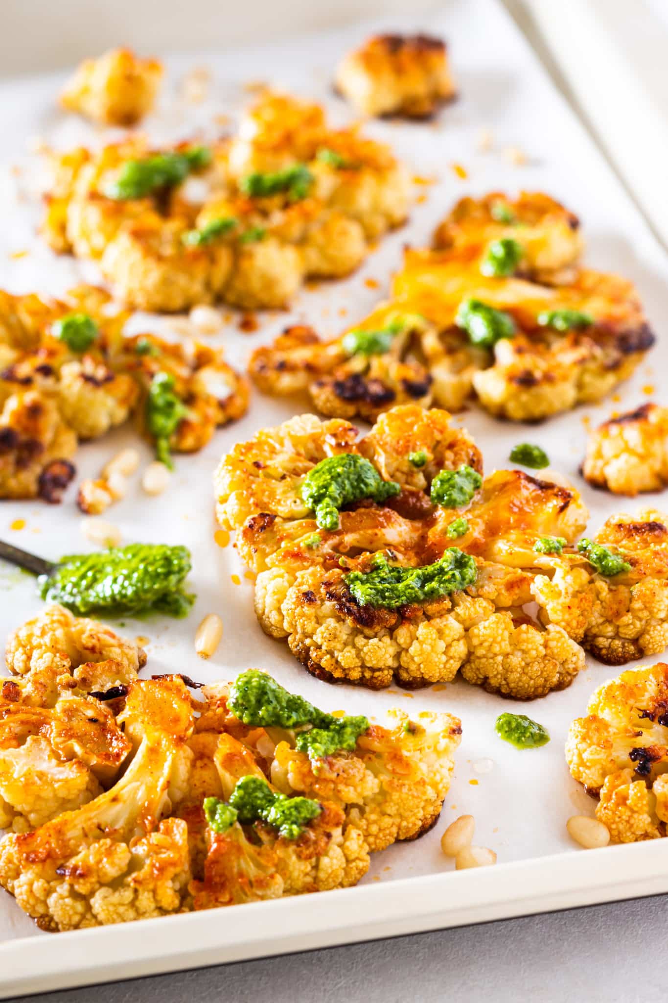 baking sheet with parchment paper and roasted cauliflower with pesto. 