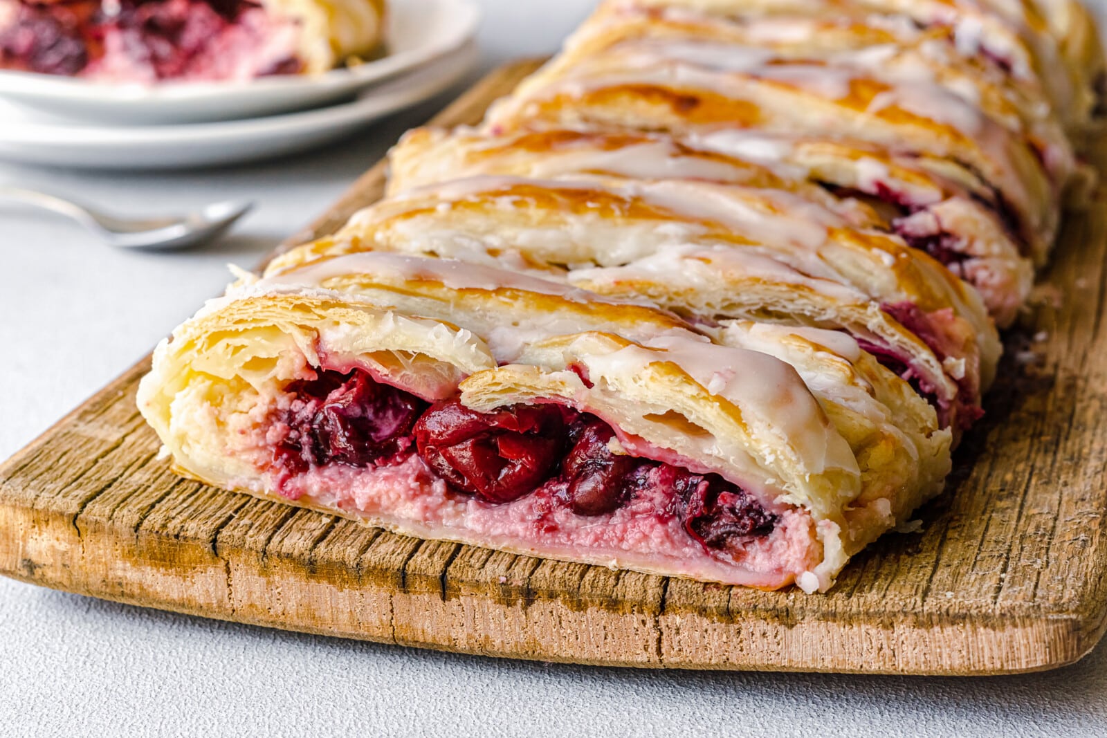 Slices of cherry cheese danish on a cutting board.