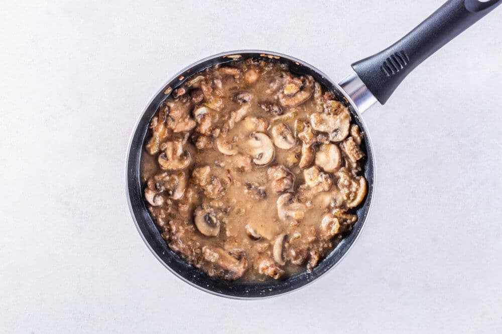 mushrooms and sauce in a black skillet.