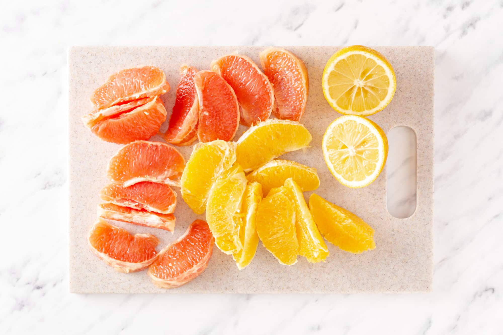 Citrus ingredients chopped on a cutting board lemon orange and grapefruit.