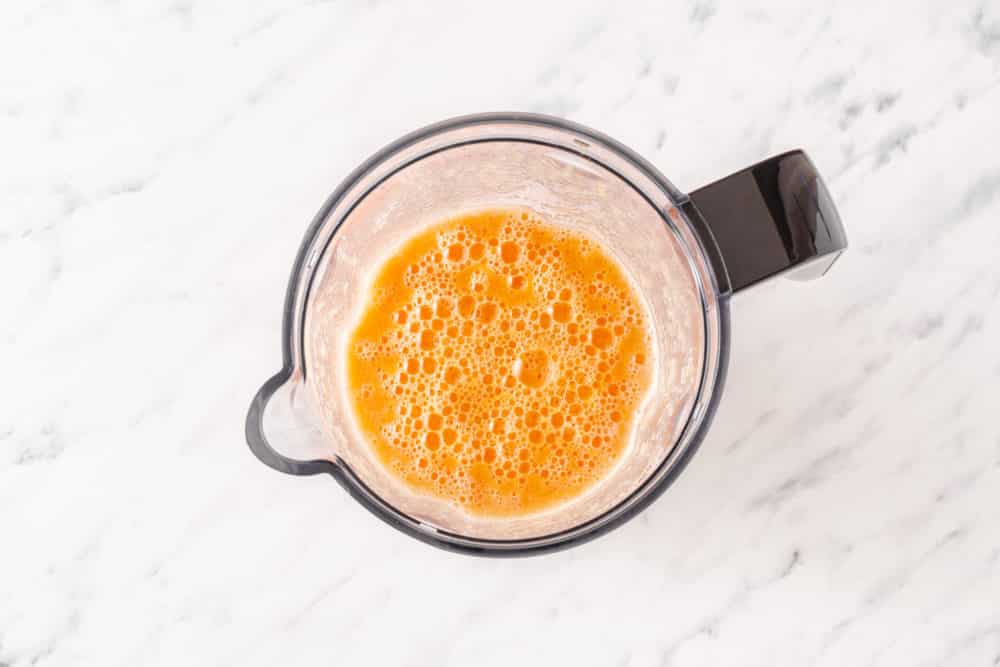 A blender with citrus smoothie.