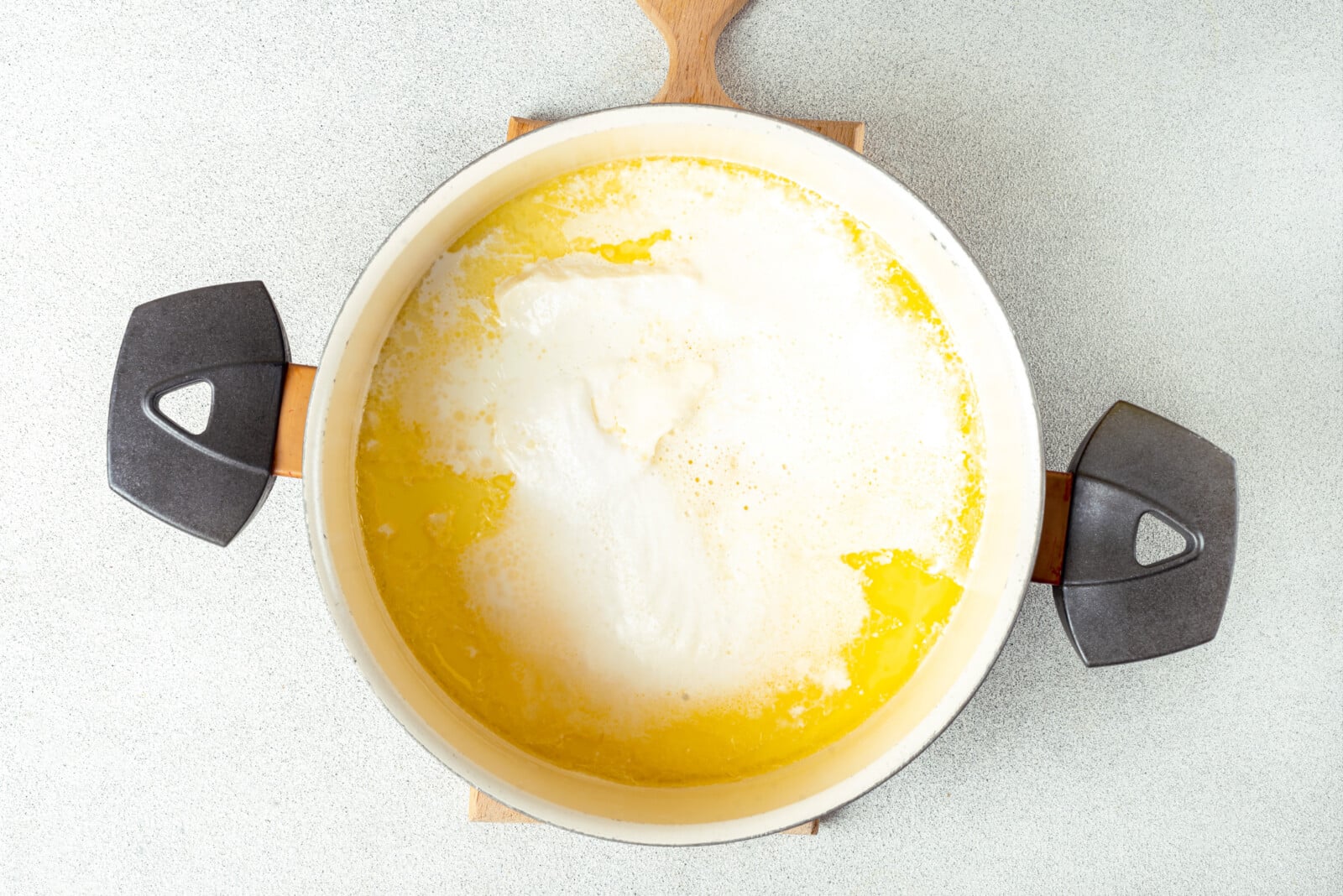 Cooking alfredo sauce in a large pot.