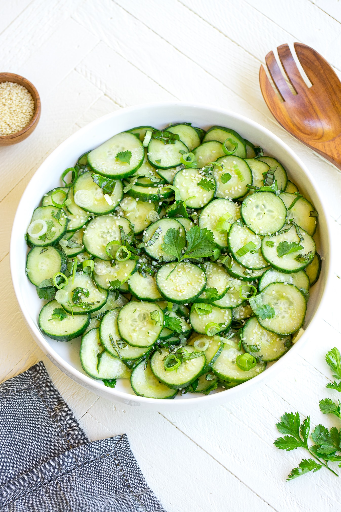 a white bowl filled with an asian cucumber salad.