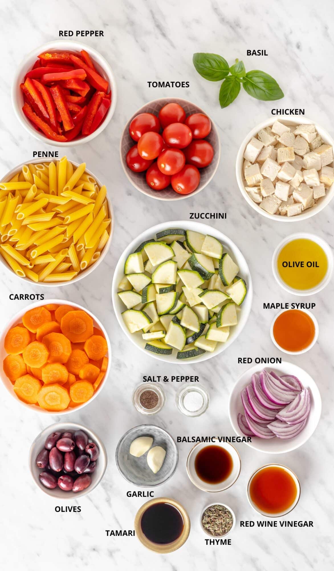 Dairy free pasta salad ingredients - tamari, red onion, red wine vinegar, olive oil, maple syrup, salt and pepper, olives, garlic, thyme, penne, red pepper, tomatoes, zucchini, carrot, and basil.