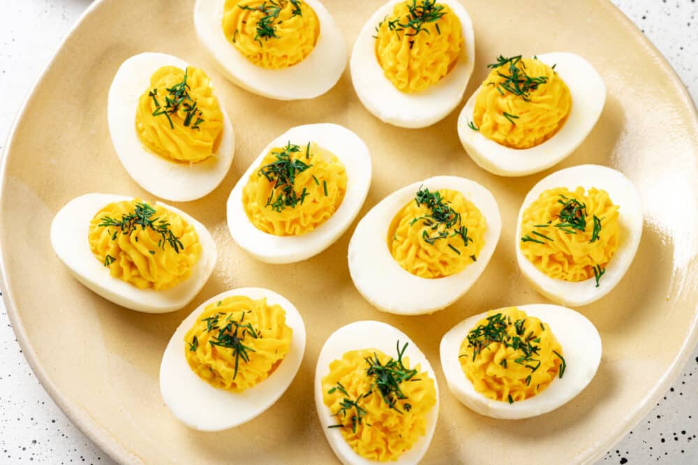 Deviled eggs with chopped dill on top.