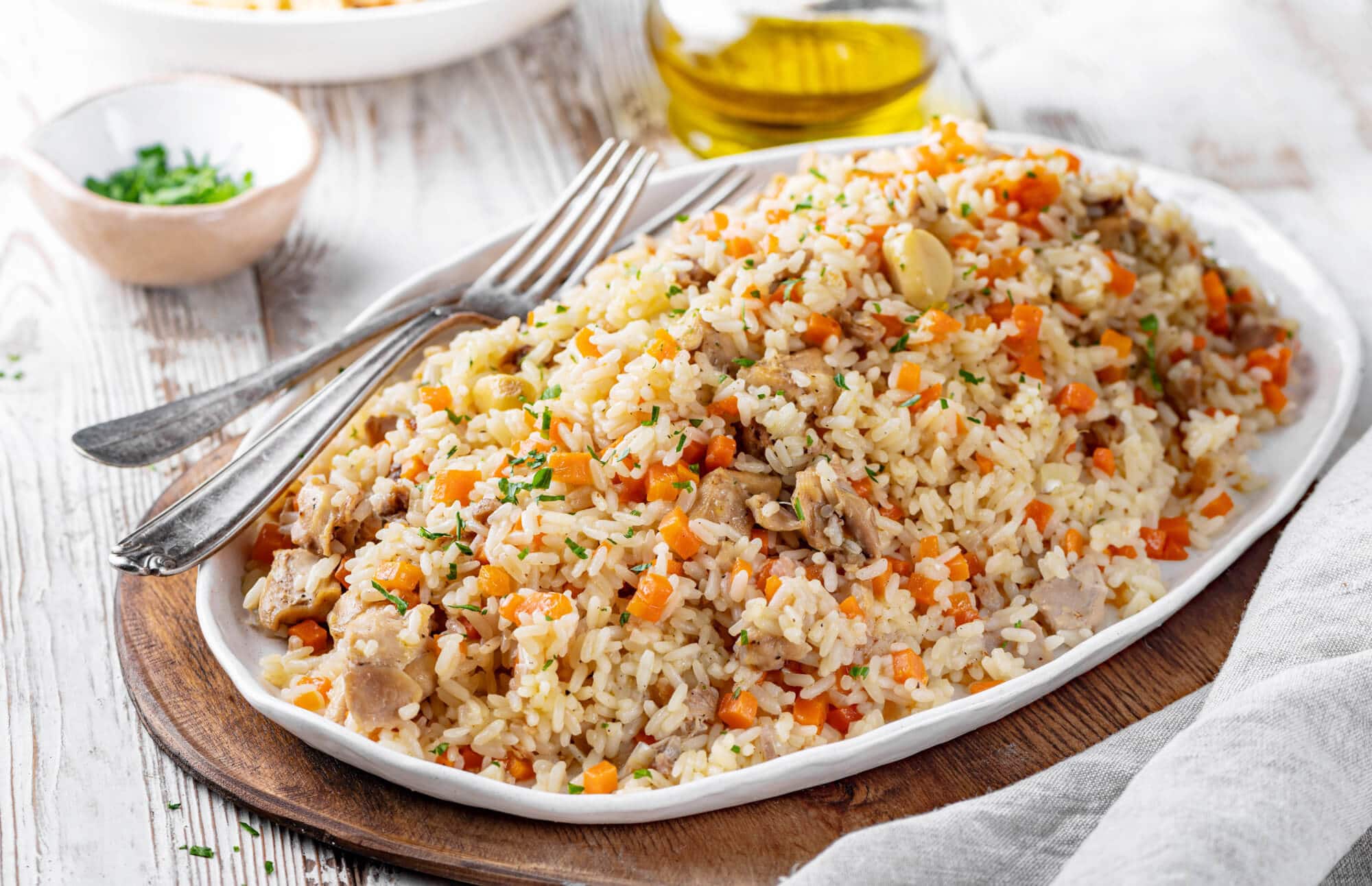 Chicken and rice recipe of plov on a white plate piled high with two forks.