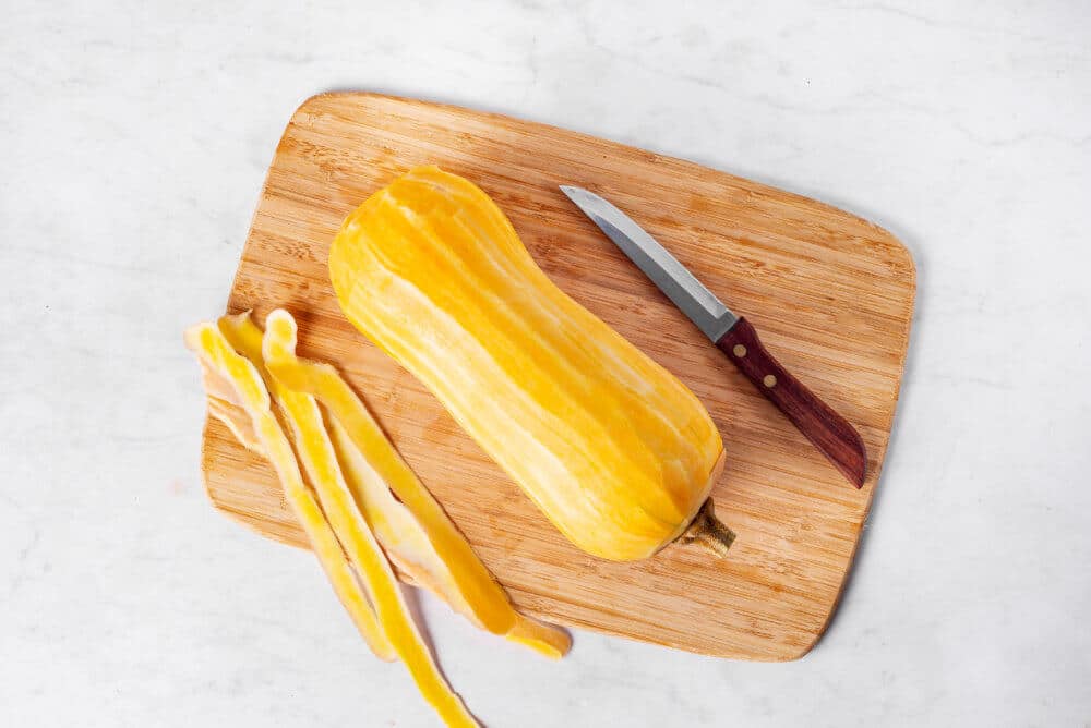 butternut-squash-whole-peeled-on-a-wooden-board-with-a-knife