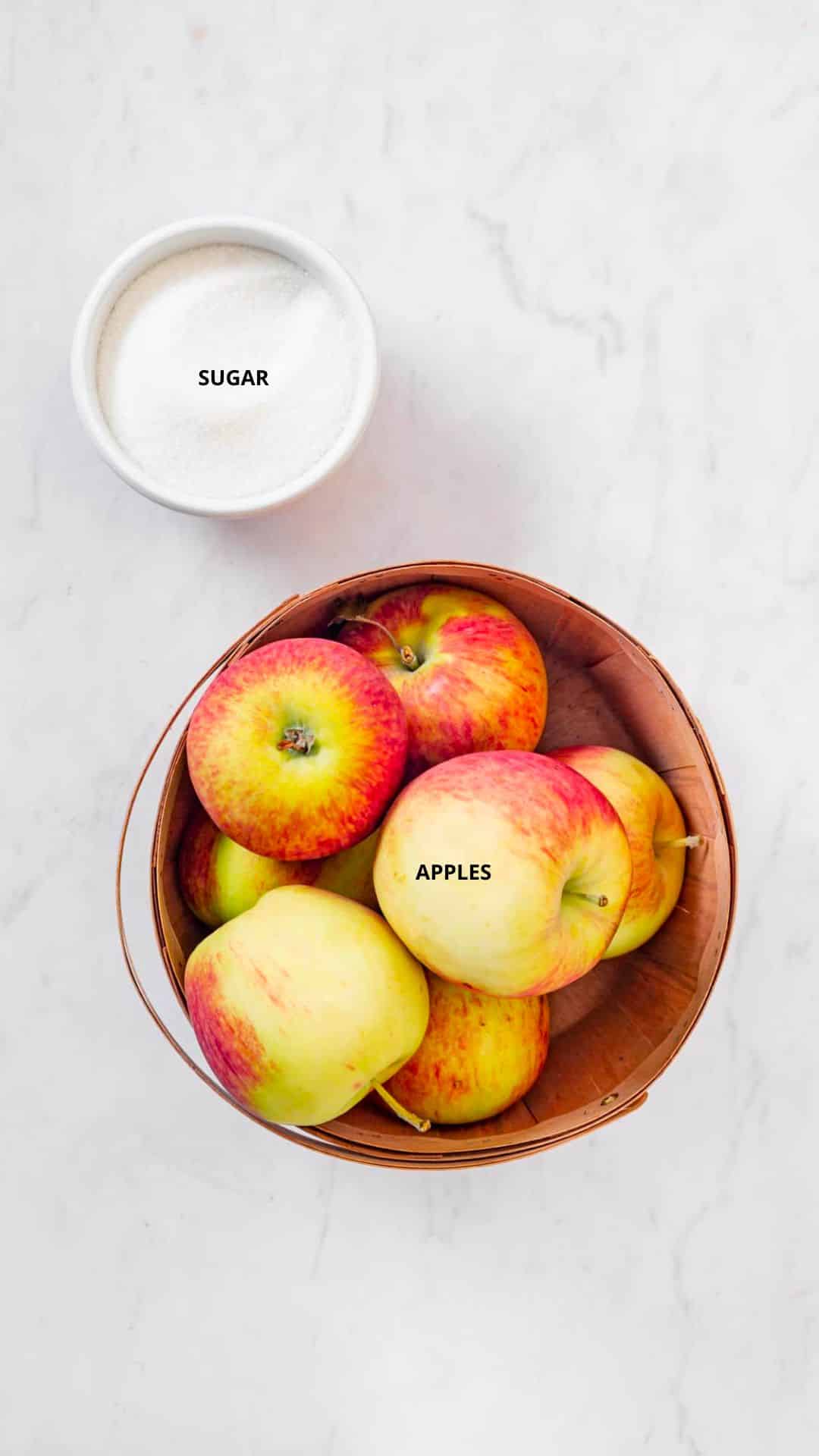 apple jam ingredients: apples in a brown bowl, sugar in a white bowl.