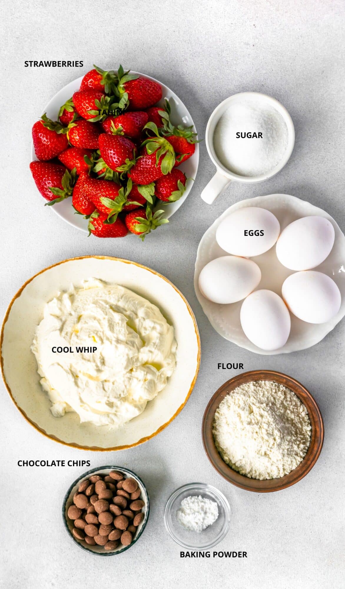 Strawberry cake roll ingredients- strawberries, heavy whipping cream, icing sugar, eggs, flour, chocolate chips, and baking powder.