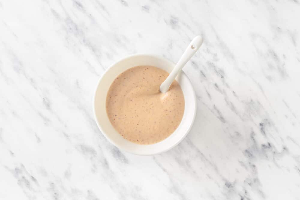 spicy sauce in a white bowl with a spoon.