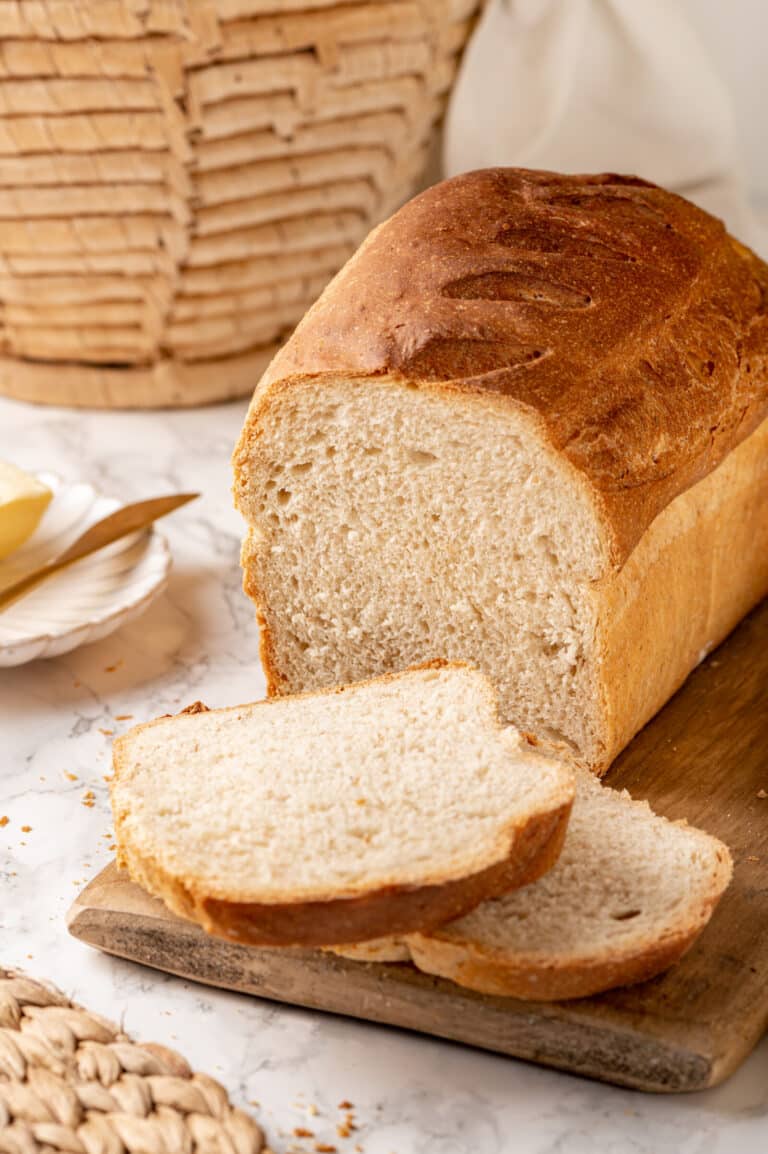 Freshly baked and sliced whole wheat bread with a basket on the side.