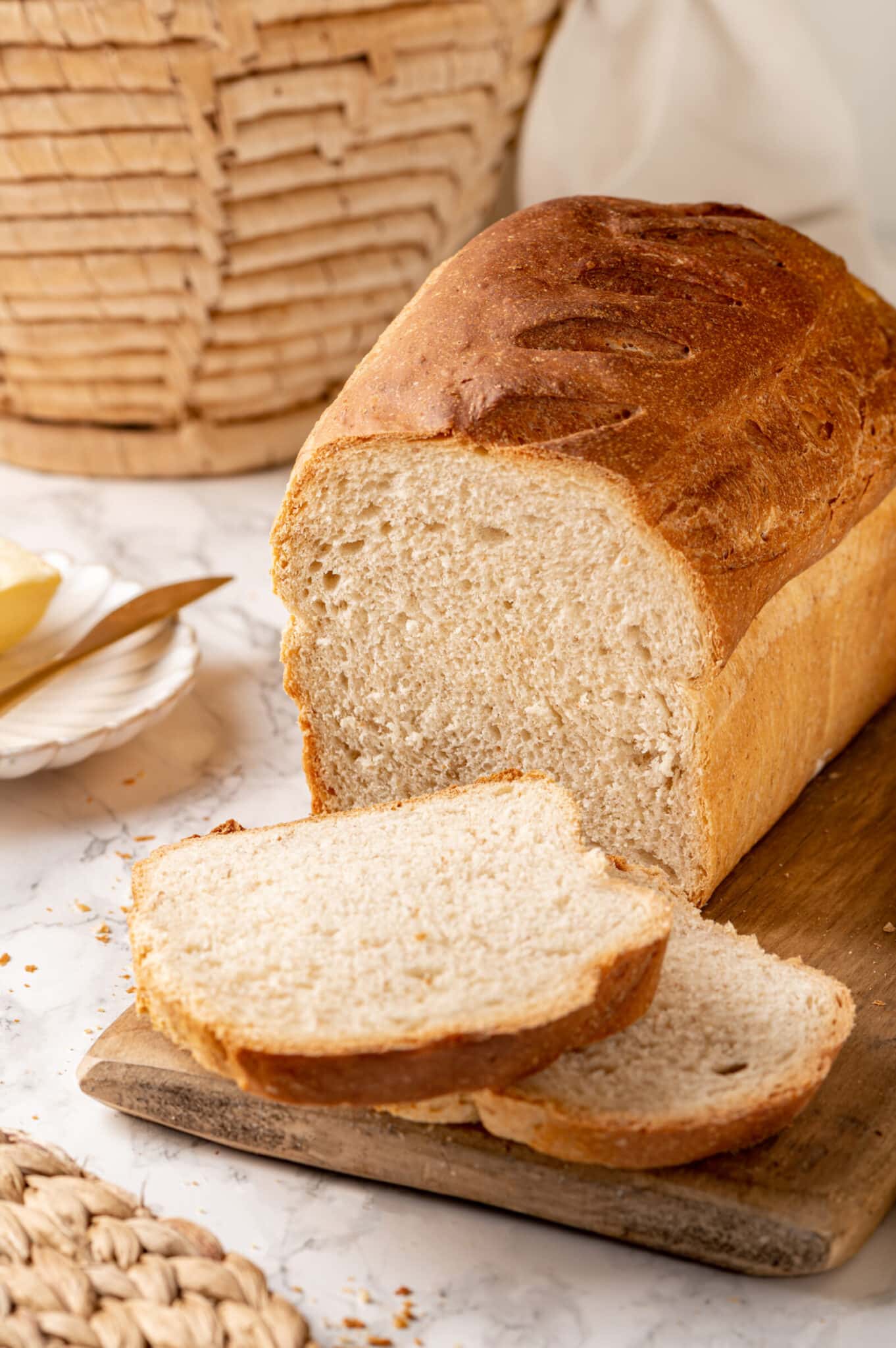 Freshly baked and sliced whole wheat bread with a basket on the side.