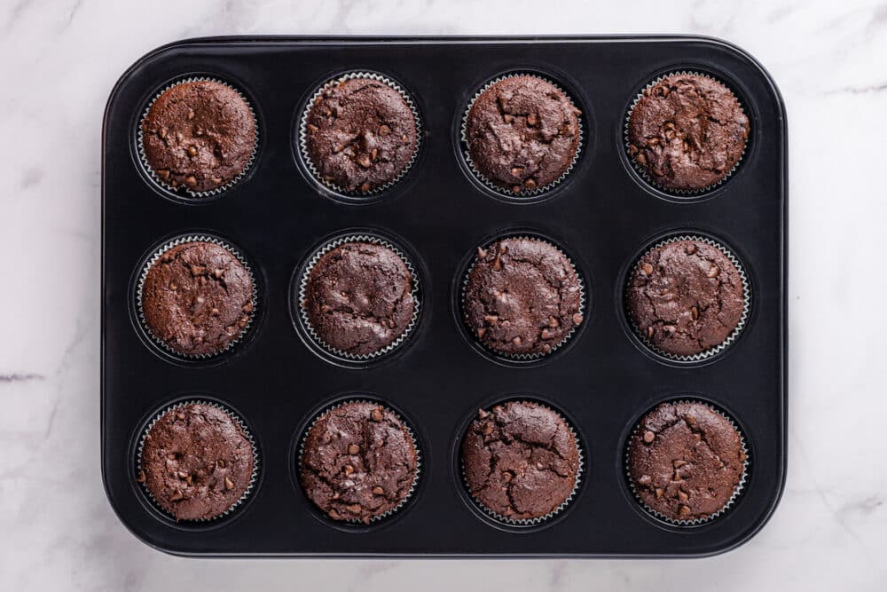 Freshly baked chocolate chip muffins in a muffin tin.