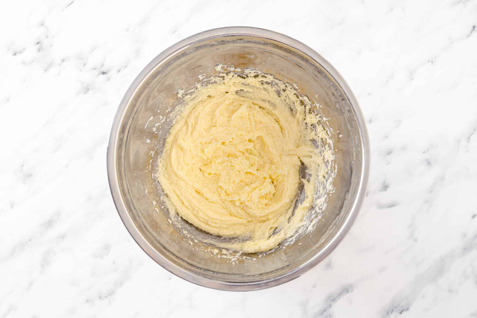 cookie dough without chocolate chips in a silver bowl. 