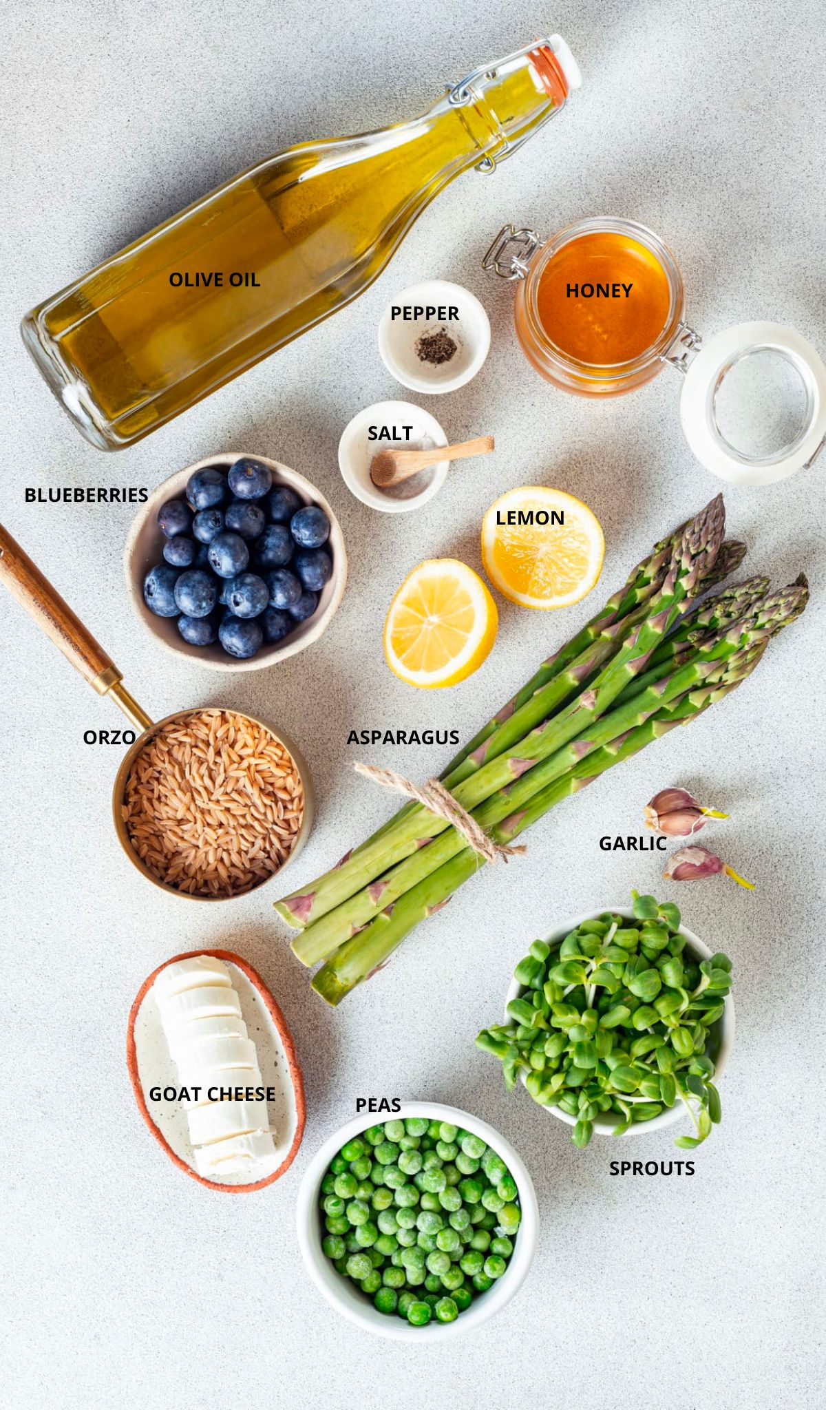 Gluten free lemon orzo salad ingredients spread with labels olive oil pepper salt honey lemon blueberries orzo asparagus garlic sprouts peas and goat cheese.