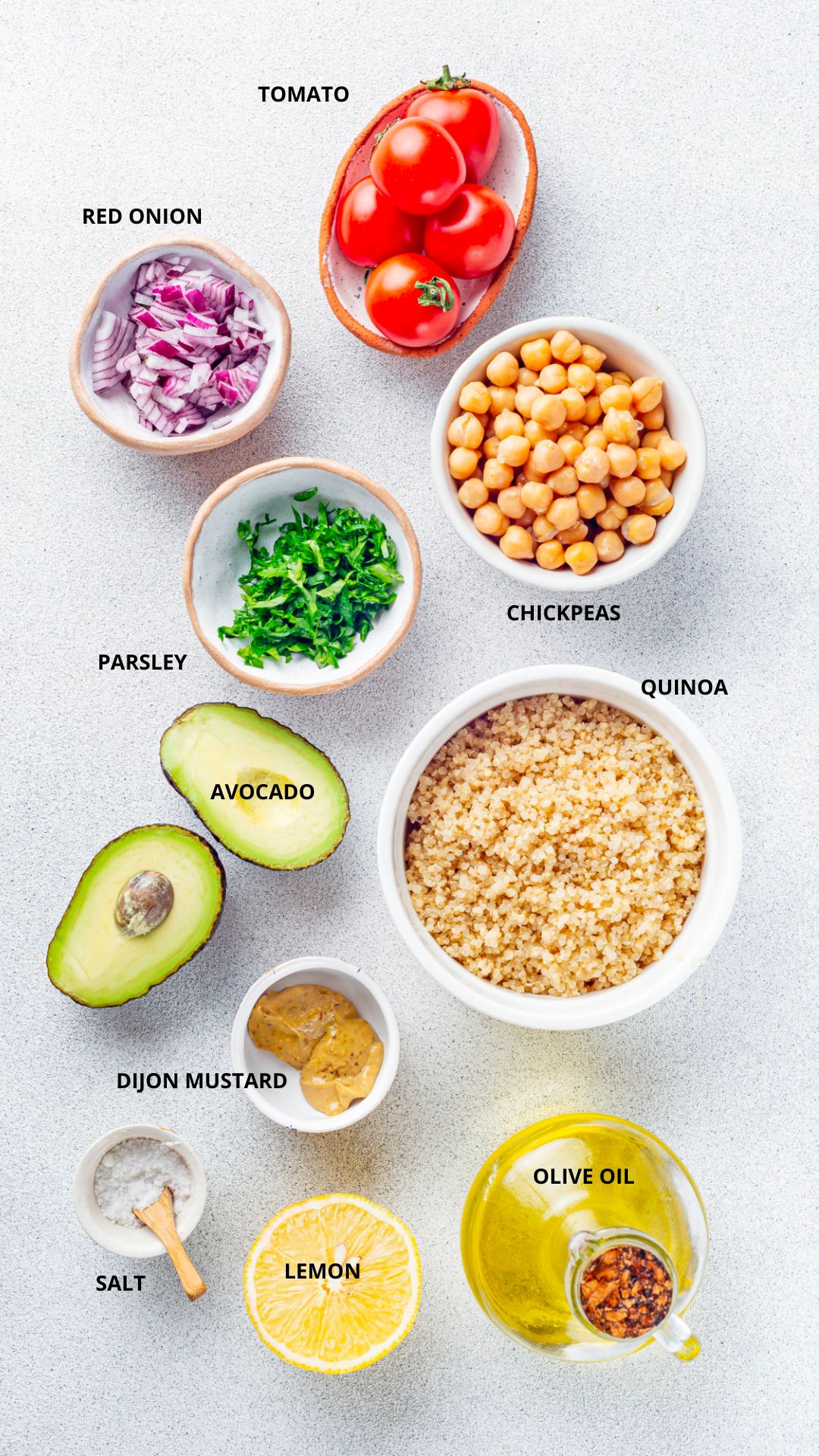 quinoa and chickpea salad ingredients- tomato, red onion, parsley, chickpeas, quinoa, olive oil, dijon mustard, avocado, salt, and lemon.