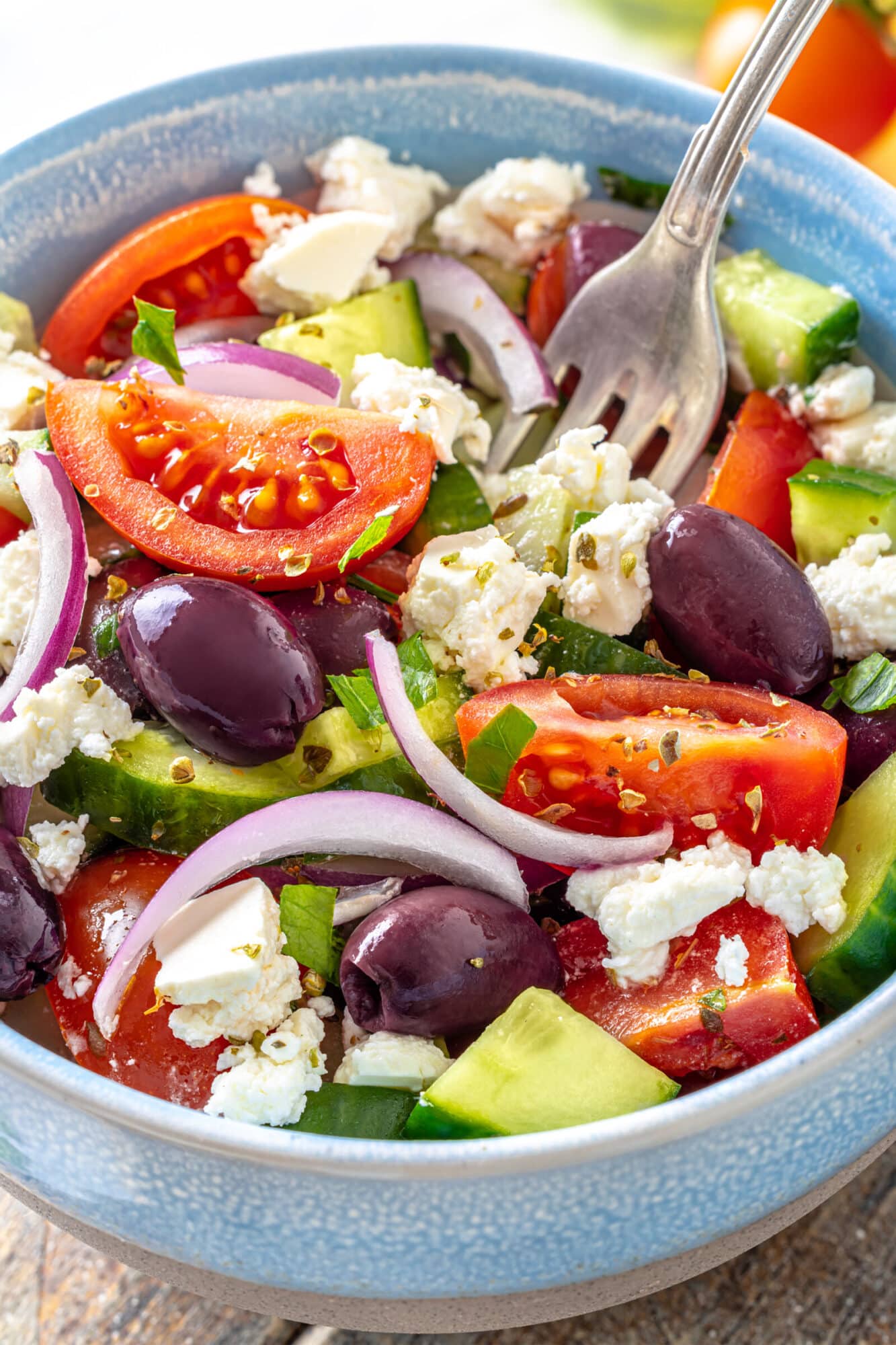 Close up of Greek salad in a bowl with a fork.