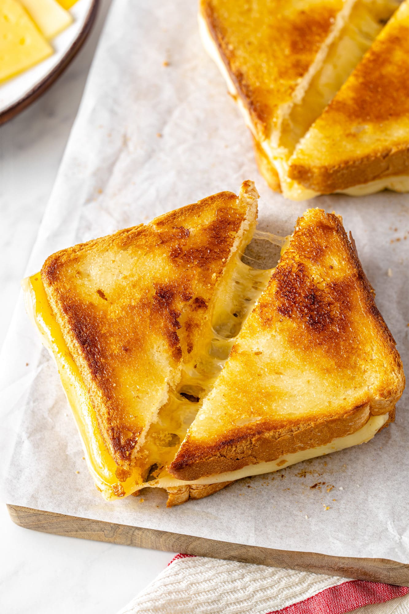 Sliced grilled cheese sandwiches on parchment paper.