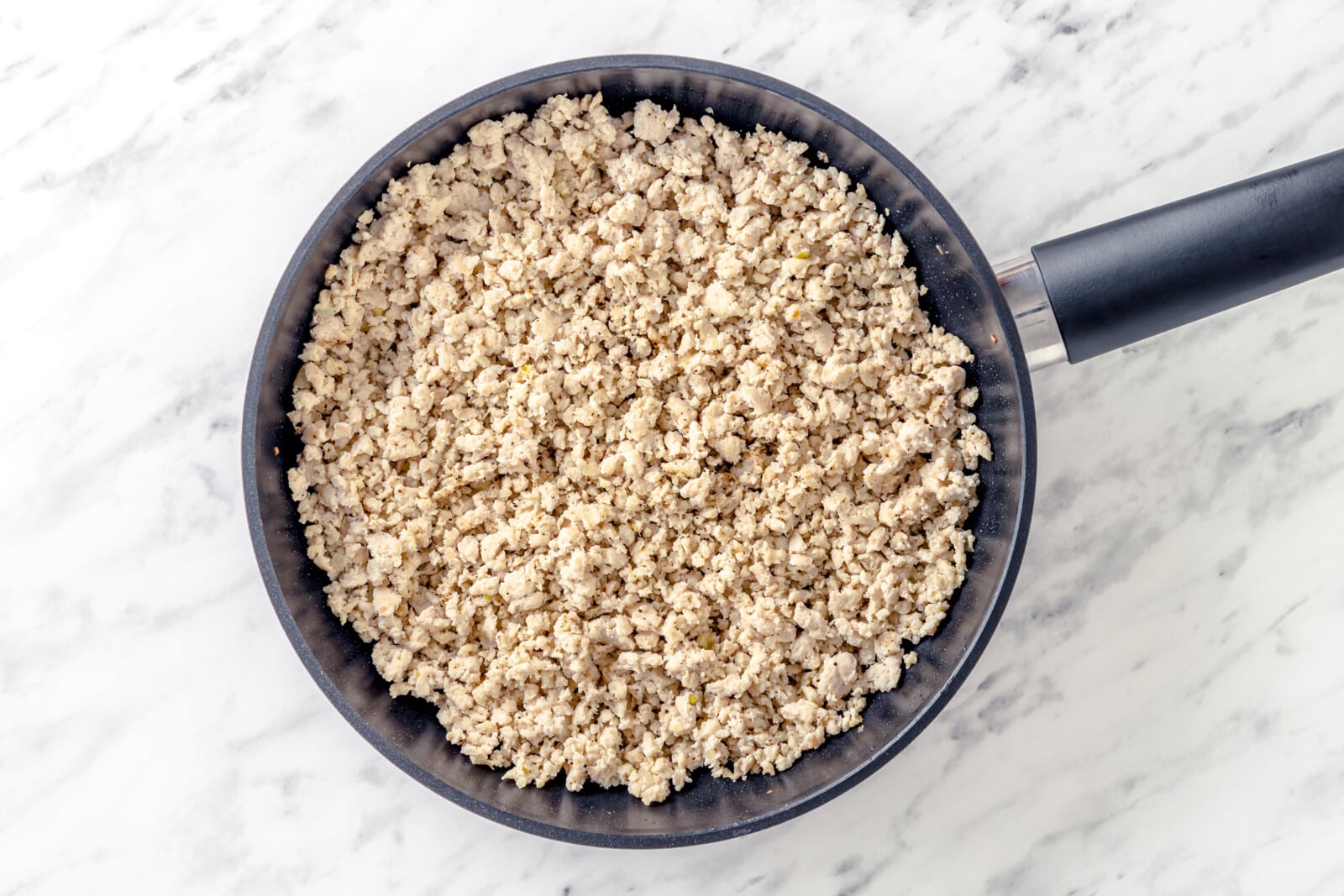 Ground chicken sautéed in a skillet.