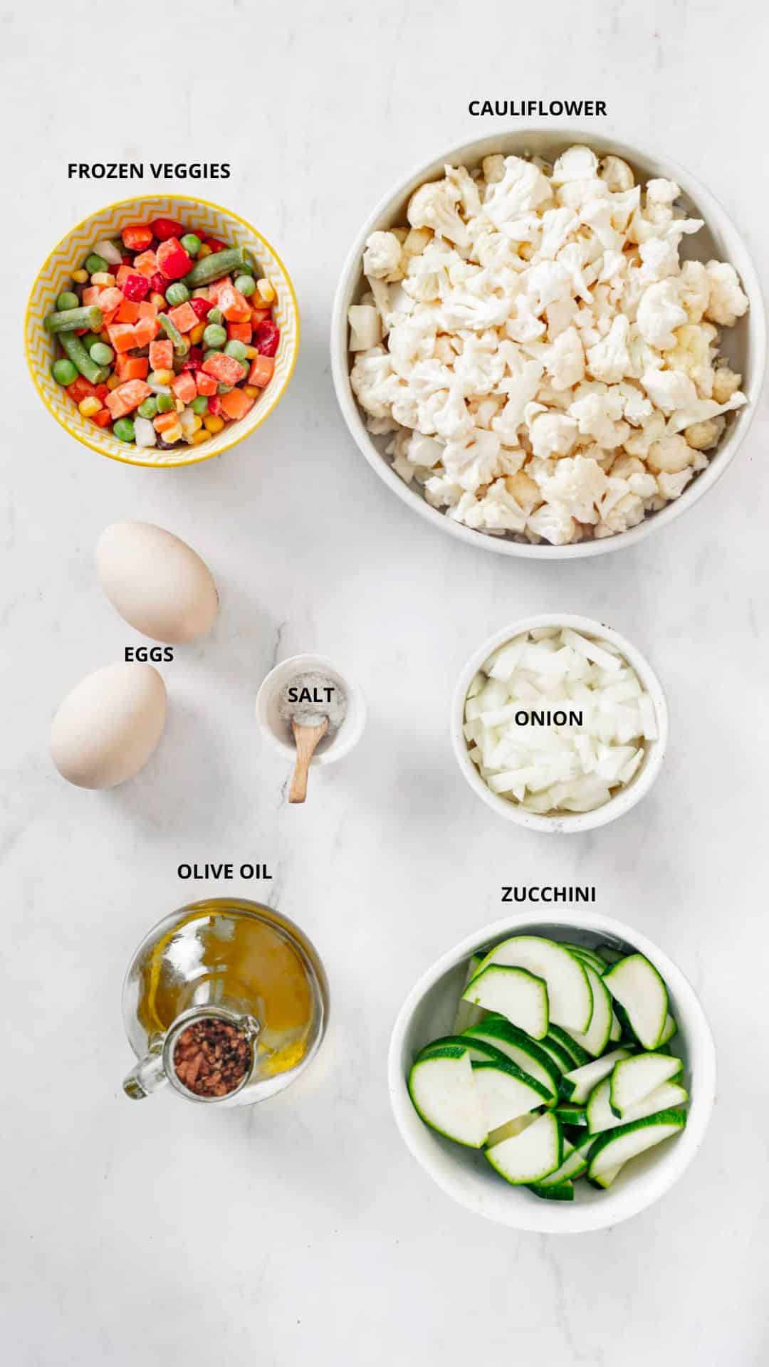 cauliflower rice ingredients cauliflower, frozen veggies, eggs, salt, onion, zucchini, and olive oil.