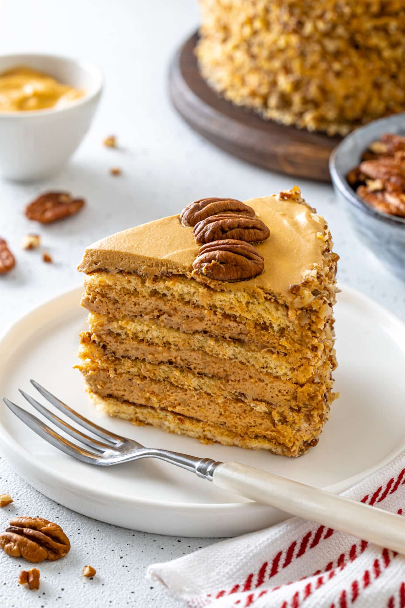 Honey pecan cake slice on a white plate ready to eat.