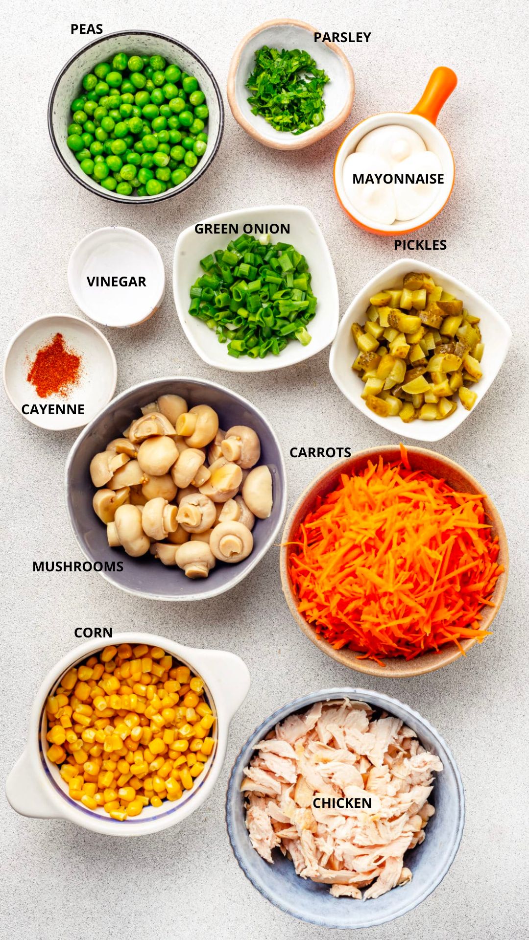 Chicken mushroom veggies salad ingredients spread peas, parsley, mayonnaise, pickles, green onion, vinegar, cayenne, carrots, mushrooms, corn, and chicken.