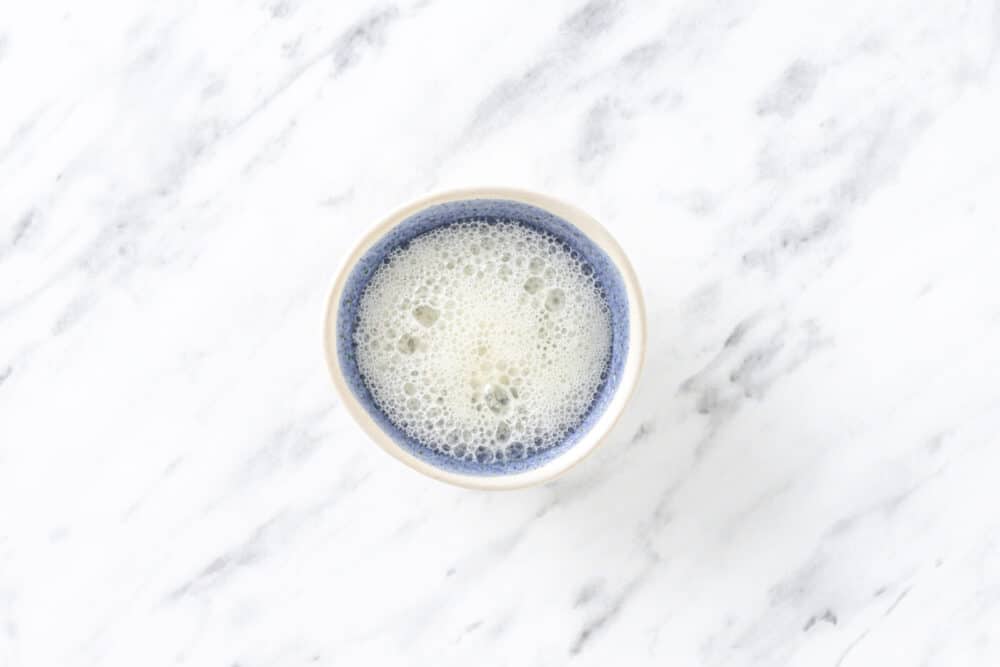 Lemon juice and baking soda mixture in a blue bowl.