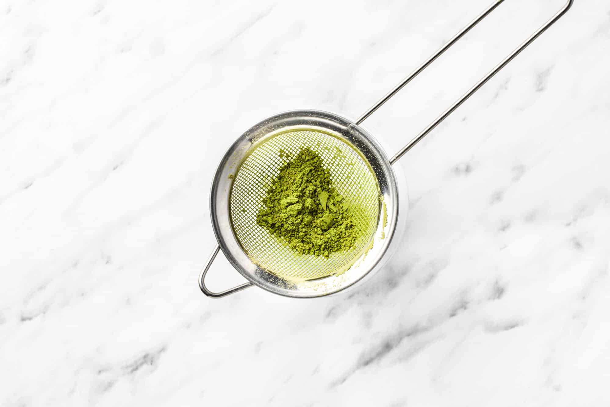 matcha powder in a sieve. 