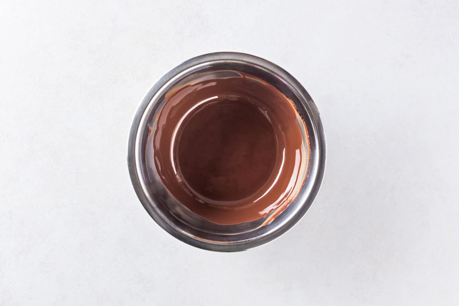 Melted chocolate for glaze in a bowl.