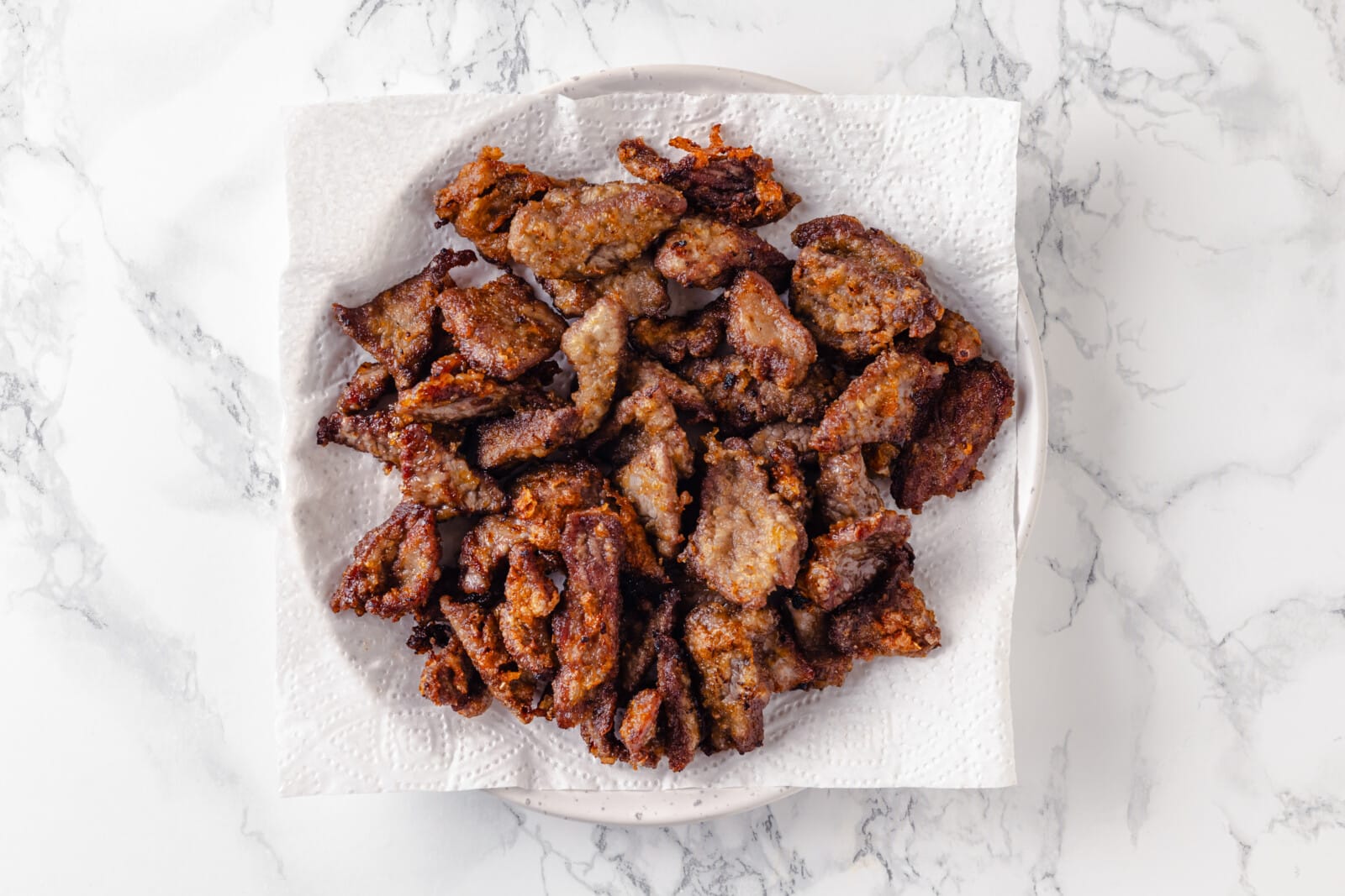 fried beef in oil on a paper towel. 