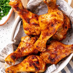 a white bowl with cooked montreal chicken wings in it on a striped blue towel.