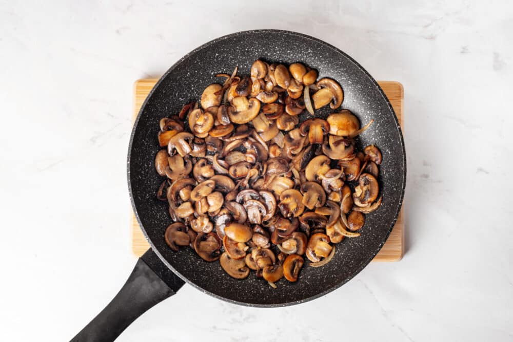 Mushrooms sautéed in a skillet.