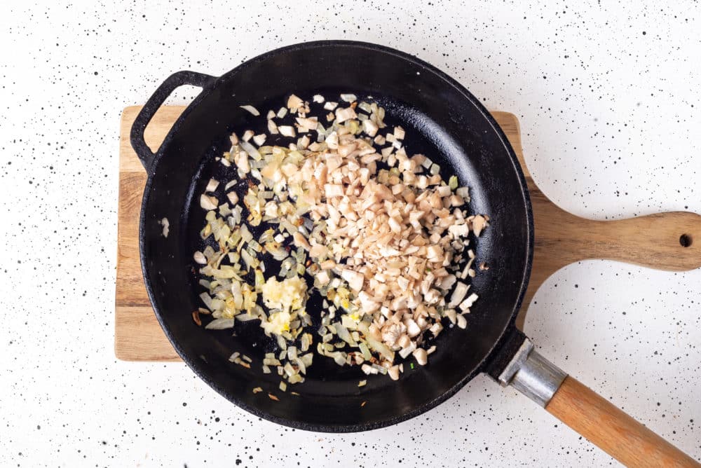 mushroom filling in a skillet on a wooden board.