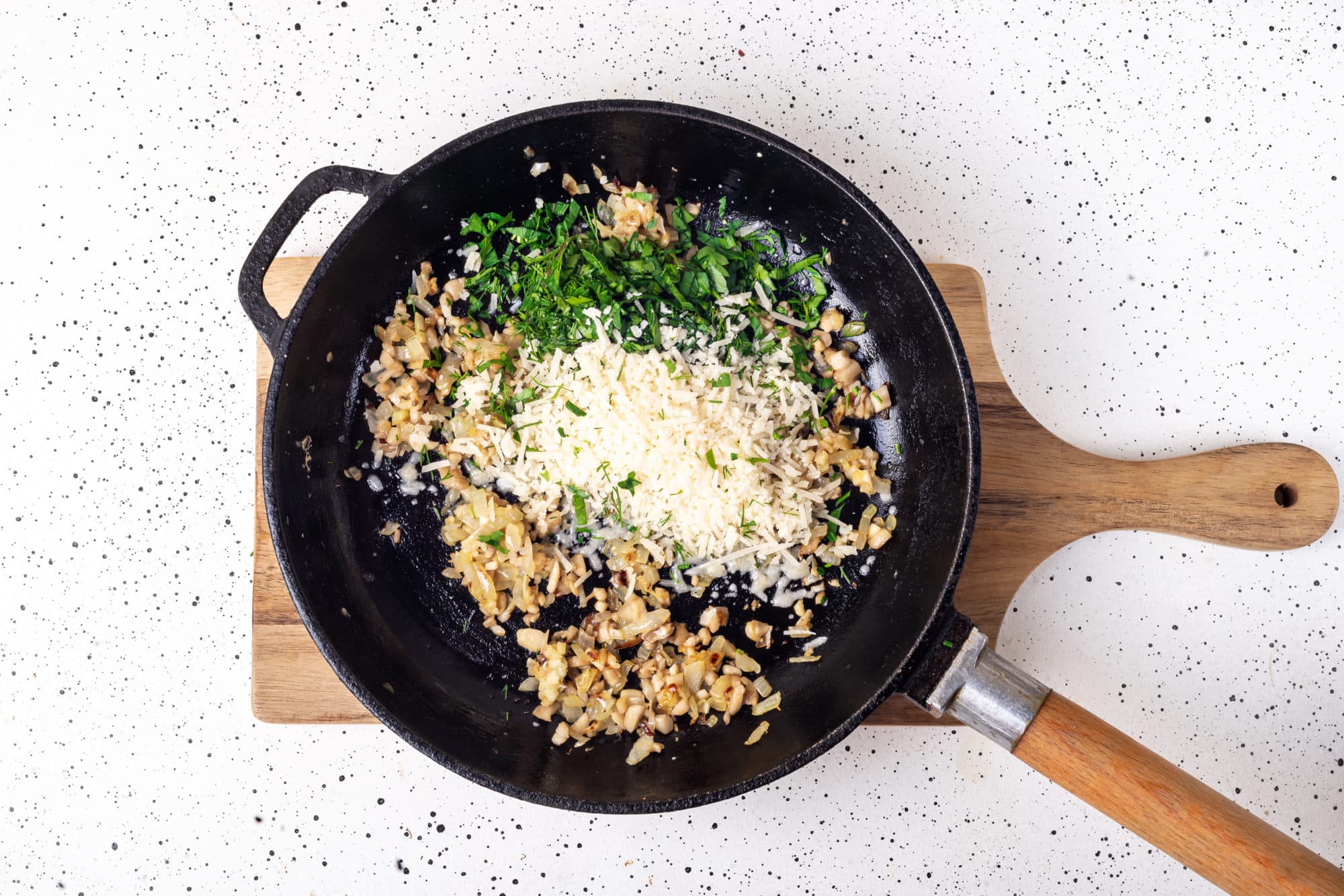 mushroom filling cooking in a skillet on a wooden board.