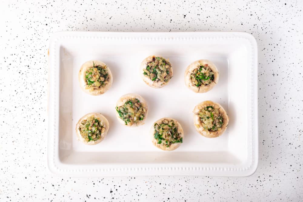 raw stuffed mushrooms in a baking dish.