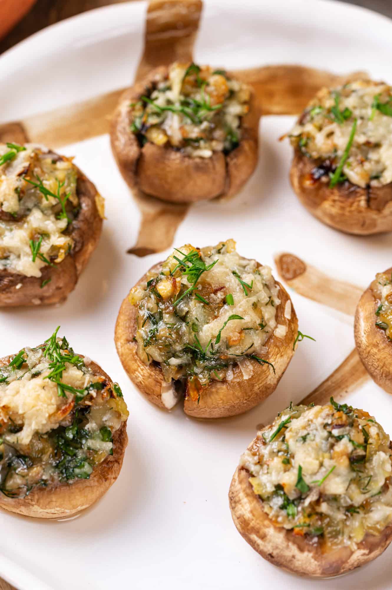 A white plate with stuffed mushrooms on it.