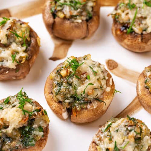 A white plate with stuffed mushrooms on it.