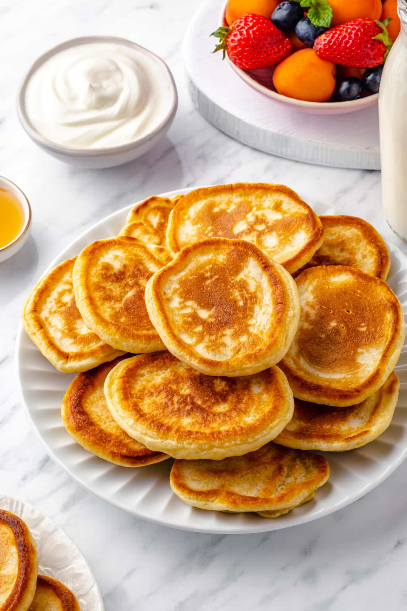 a bunch of small oladky ukrainian pancakes on a white plate