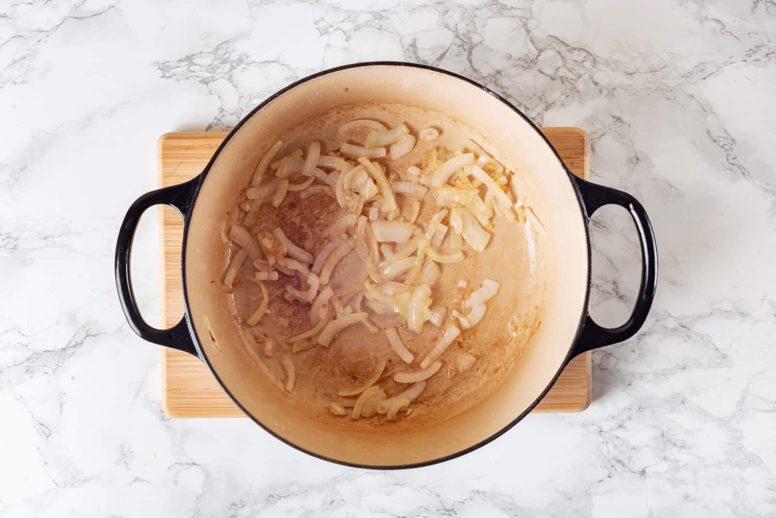 Onions and garlic sauteing in a pot.